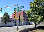 Thumbnail 30 of 36 - Street corner view with traffic signal and signage at 68 Beale Apartments, Quincy, Massachusetts